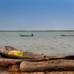 Cacheu, Republic of Guinea-Bissau - February 1, 2018: Fishermen on their canoes in the Cacheu River near the city of Cacheu, in Guinea Bissau.
